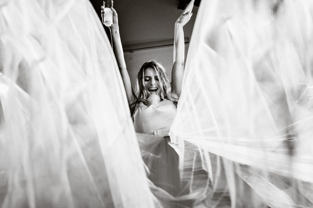 bride dancing with the dress being held by the guests