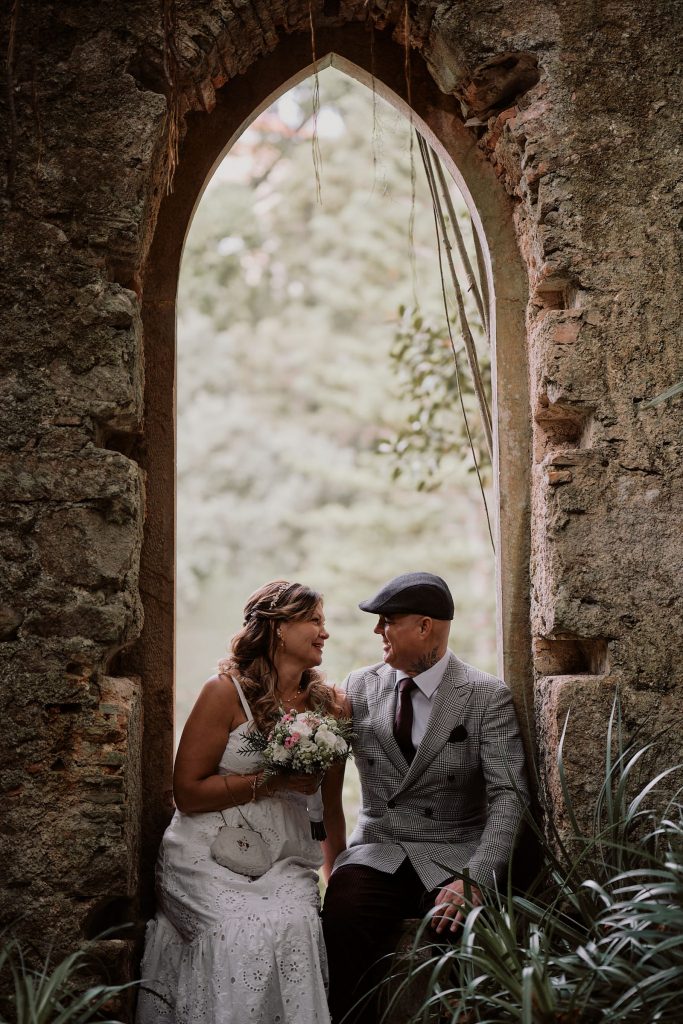Couple sitting in the window of the ruins of church in Monserrate, Sintra